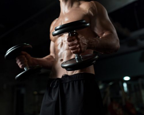 close-up-of-man-with-dumbbells-exercising-in-gym-PNGBLV9-min.jpg